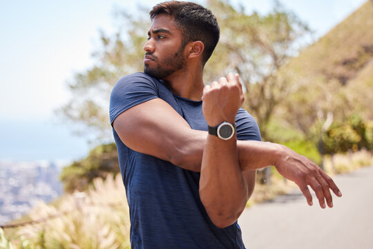 Thinking, man or runner stretching arms for fitness training, wellness or exercise outdoors on road. Relax, muscle flexibility and healthy Indian male athlete in warm up to start running workout - Powered by Adobe