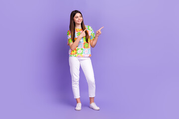 Full size photo of cheerful lovely person wear stylish t-shirt indicating look at offer empty space isolated on purple color background