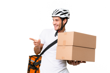 Delivery man wearing a helmet bike over isolated background pointing finger to the side and presenting a product