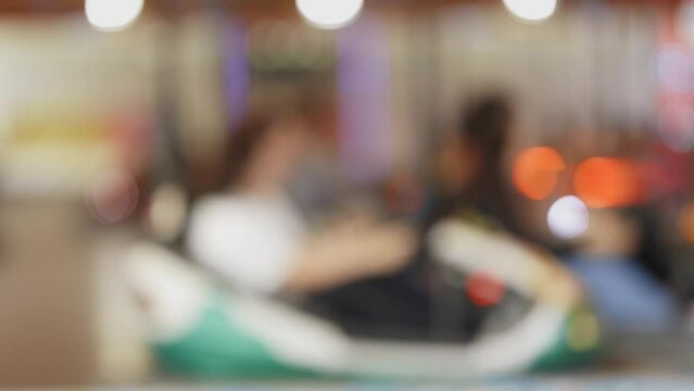 Blurred people riding dodgems - kids attraction