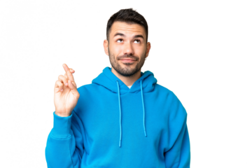 Young handsome caucasian man over isolated chroma key background with fingers crossing and wishing the best