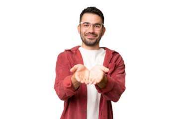 Young handsome caucasian man over isolated chroma key background holding copyspace imaginary on the palm to insert an ad