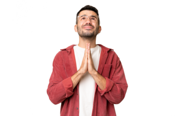 Young handsome caucasian man over isolated chroma key background keeps palm together. Person asks for something