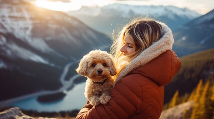 fluffy dog and woman. friendship hug with snow, lake and mountain view background.