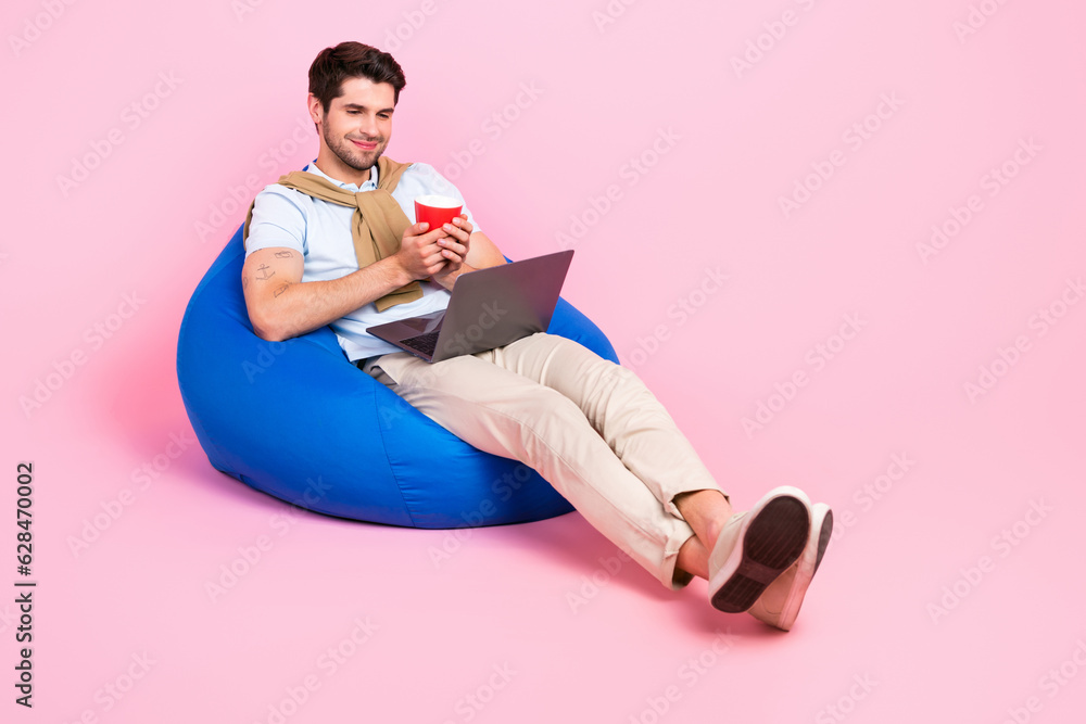 Poster full body portrait of peaceful nice man sit comfy bag hold coffee mug watch movie netbook empty spac
