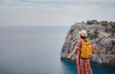 Asian woman in hat look on views of azure Bay in Mediterranean sea. Travel and vacation concept....