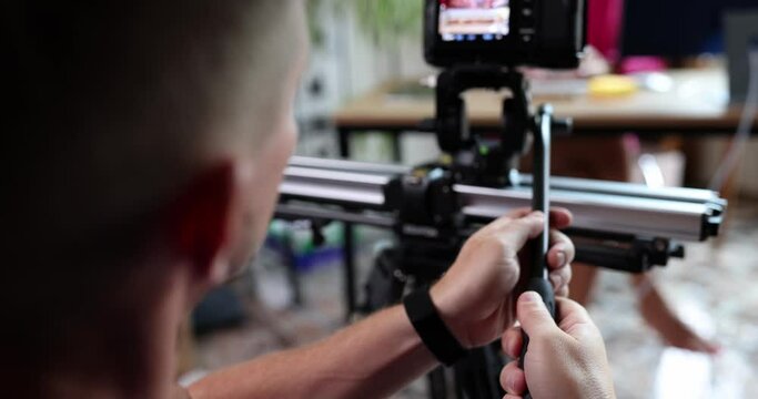 Videographer filming tutorial videos for video blog on tripod in office. Shooting high-quality content for vlog