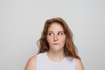 Fototapeta premium Thinking woman on white background. Doubt and idea concept