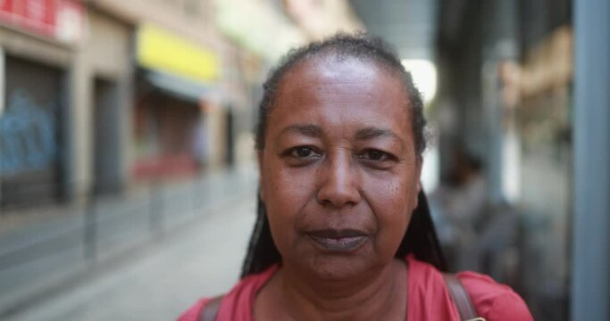 Senior african woman looking on camera at tram station
