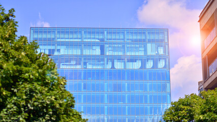  Reflection of modern commercial building on glass with sunlight. Eco architecture. Green tree and...