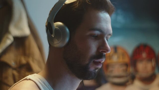 Close profile shot on face of focused man wearing headphones working on computer