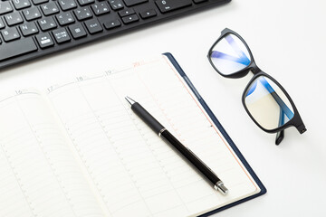パソコンと手帳とメガネ