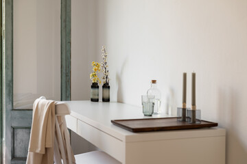 Minimalist interior with neutral colors and natural light: Room with table, chair, and vase of flowers