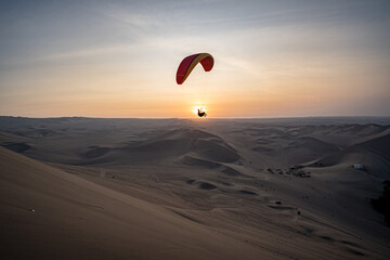 Paragliding during the Sunset in the Huacachina oasis in Ica, Peru - 628495638