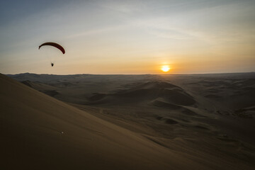 Paragliding during the Sunset in the Huacachina oasis in Ica, Peru - 628495683