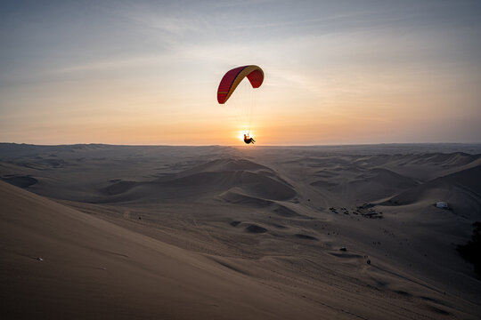Paragliding during the Sunset in the Huacachina oasis in Ica, Peru