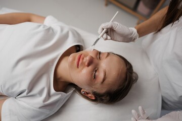 Obraz na płótnie Canvas Applying gel on a woman's face. Care for a woman's face.