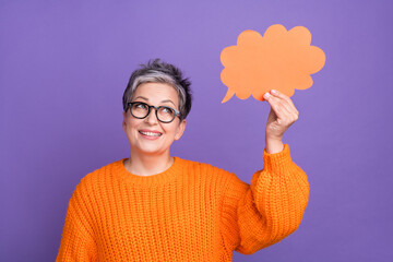 Portrait of cheerful nice person with gray hairstyle wear knit jumper look at dialog bubble in hand isolated on violet color background