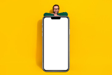 Full length photo of positive guy inside behind huge empty space placard isolated on yellow color background