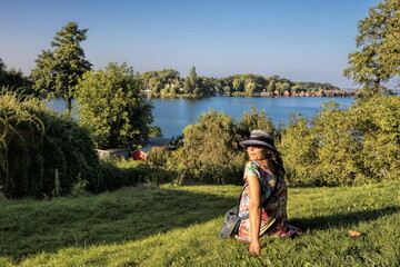 röbel, deutschland - frau mit hut am ufer der müritz lächelt in die kamera