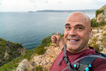 Smiling happy man takes a selfie with a beautiful natural background
