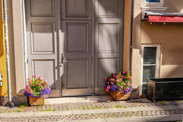 Antique front door and paving stone pavement with flower pots.