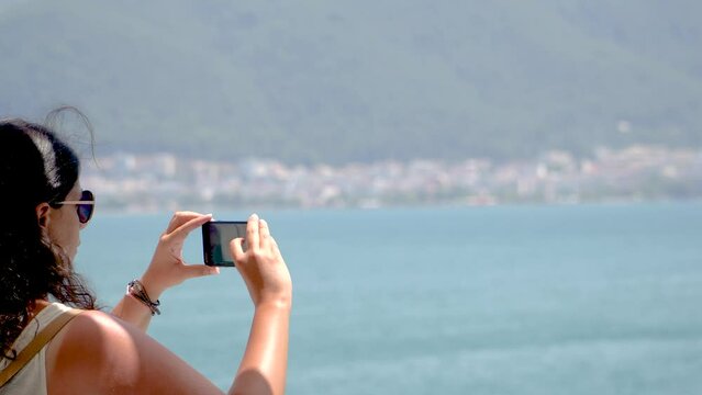 Brunette Woman Takes Pictures or Making Video of Sea Landscape with Smartphone, Summer Theme, Real time shot