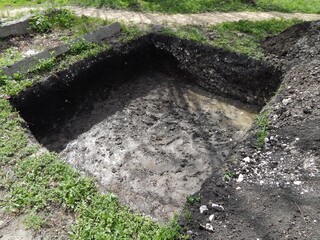Deep square trench.. A hole dug for a foundation.  - 628523853