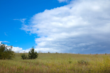 Landscape image of countryside of Ukraine. Cloudy sky, grassy fields and rolling hills rural scenery
