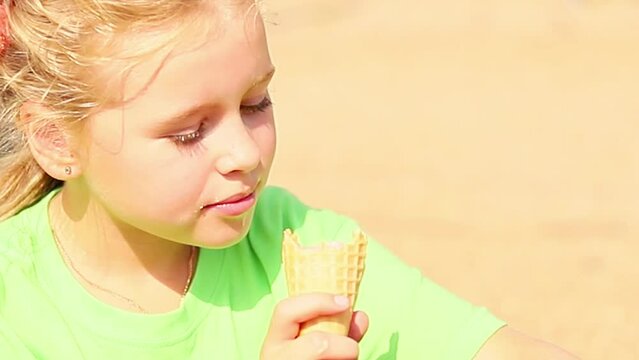 Little cute girl eats ice cream in summer, close-up