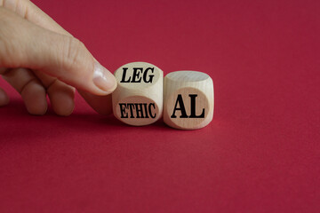 Ethical or legal symbol. Businessman turns wooden cubes and changes the word Ethical to Legal on a beautiful burgundy background. Business and ethical or legal concept. Copy space.