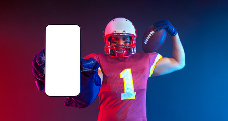 American Football Player. Mobile Phone App Advertisement. Sports Betting on American Futball. Bets Application. Handsome Man Showing At White Empty Smartphone Screen. Cellphone Display Mock Up