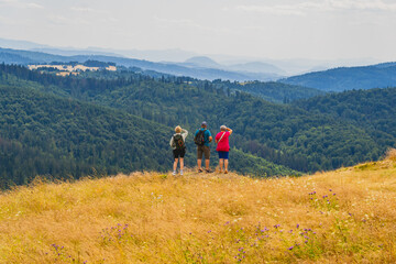 People looking from the top of the Ochodzita mountain to the Beskidy Mountains.