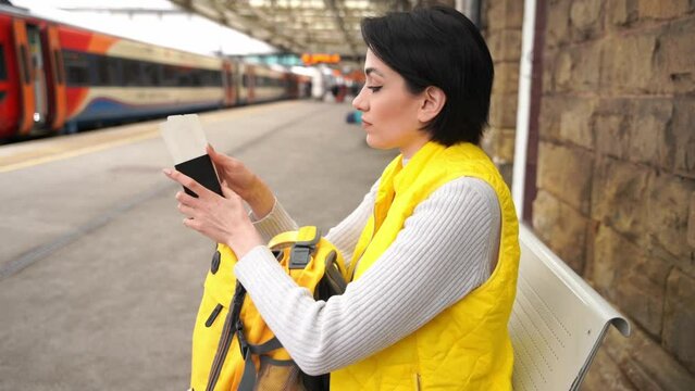 young woman holding passport and tickets, and waiting for train at railway station Enjoying travel concept	