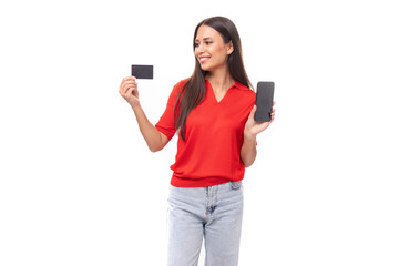 Naklejka premium young caucasian female model with black straight hair dressed in a red t-shirt holding a credit card and smartphone mockup