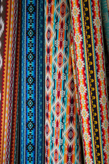 Brightly colored traditional fabric with inca motifs for sale at Otavalo market in Ecuador.  Vertical view