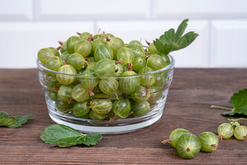 Green ripe gooseberries on a wooden table.
