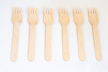 Disposable eco friendly wooden forks on white background. Eco friendly disposable wooden cutlery on white background.