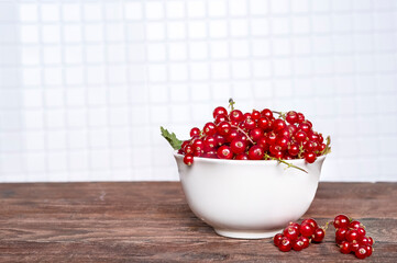 Red currant berries in a cup in the kitchen.