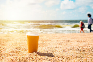 Conservation of nature.Paper mug, cup of coffee in the sand of sunny beach. summer. take away. breakfast.