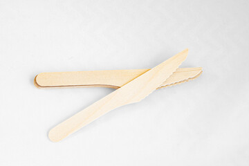 Disposable eco friendly wooden knifes on white background. Eco friendly disposable wooden cutlery on white background.