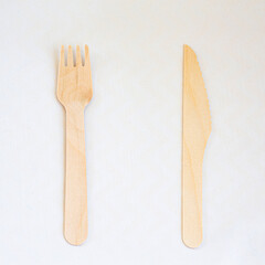 Disposable eco friendly wooden fork and knife on white background. Eco friendly disposable wooden cutlery on white background.