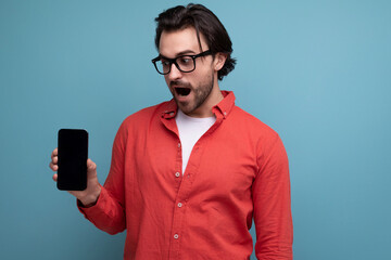 surprised stylish european 35 year old man in casual shirt studying phone screen