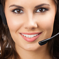 Portrait of happy smiling young support phone operator or businesswomen in headset, with blank...