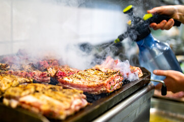 woman chef hand cooking pork ribs on grill in kitchen