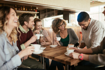 Diverse group of young people talking and having a coffee at a cafe