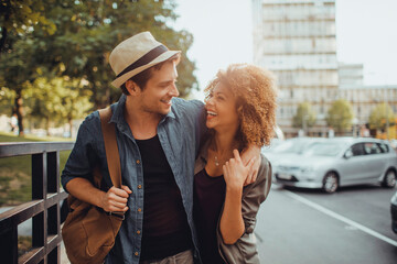 Young couple walking down a street in the city while traveling on their vacation © Geber86