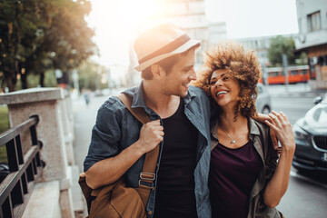 Young couple walking down a street in the city while traveling on their vacation