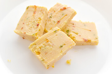 Spicy cheese slices on a white plate. 