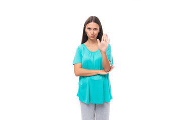 young brunette european lady with straight hair wearing a blue t-shirt seriously asks to stop